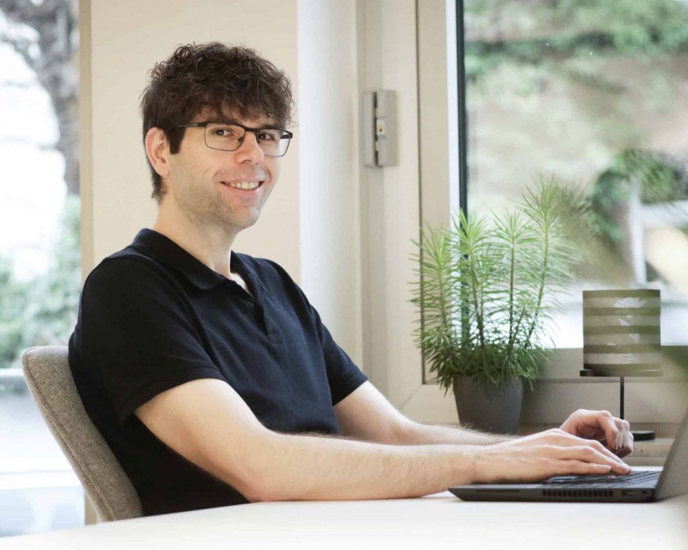 T-Berater sitzt entspannt am Schreibtisch vor dem Laptop – Symbol für zuverlässige, skalierbare IT-Betreuung durch Masedo